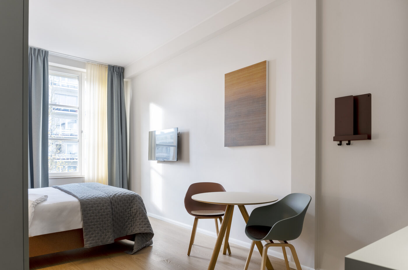 Keyinn Serviced Residences Belair room with ase ating area, and a wall-mounted TV.