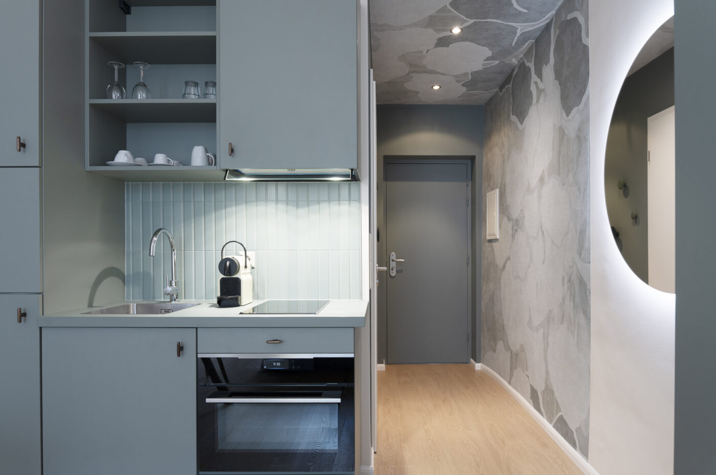 Keyinn Serviced Residences Belair kitchen with blue cabinets, integrated appliances, and a coffee station.