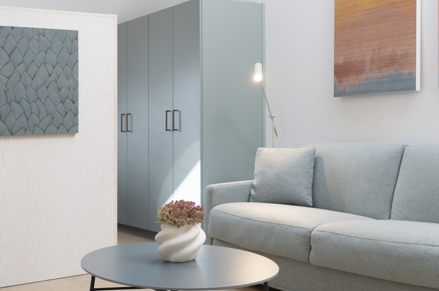 Keyinn Serviced Residences Belair living room with a blue sofa, matching cabinets, and a dining table with flowers. The space includes abstract wall art and a serene, minimalist design.