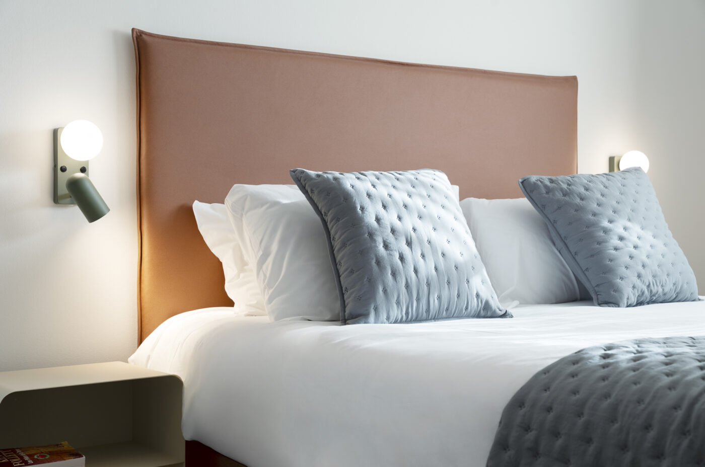 Keyinn Serviced Residences Belair bedroom with a bed, headboard, and linens. The space includes tufted pillows and integrated side lighting.