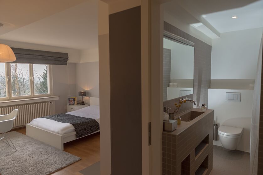Keyinn Serviced Residences apartment with a single bed area near a large window. Featuring an adjoining bathroom.